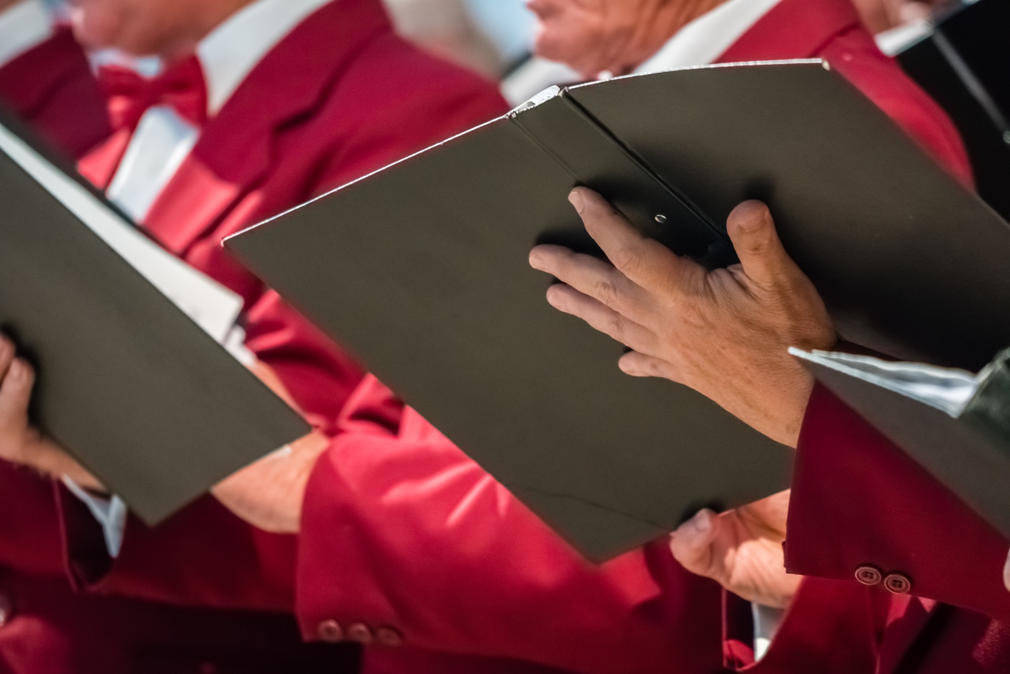 Mens choir members holding singing book Mens choir members holding singing book